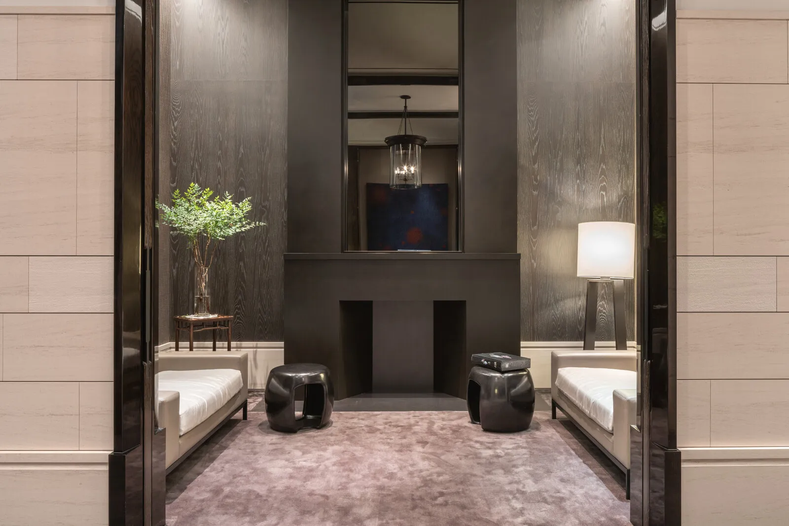 A seating alcove off the main floor, two benches and an olive tree either side of a stone hearth