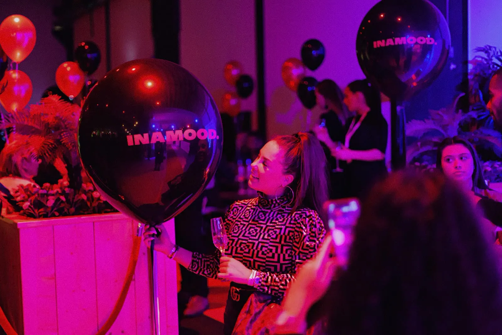 A guest holding a branded INAMOOD balloon at the launch