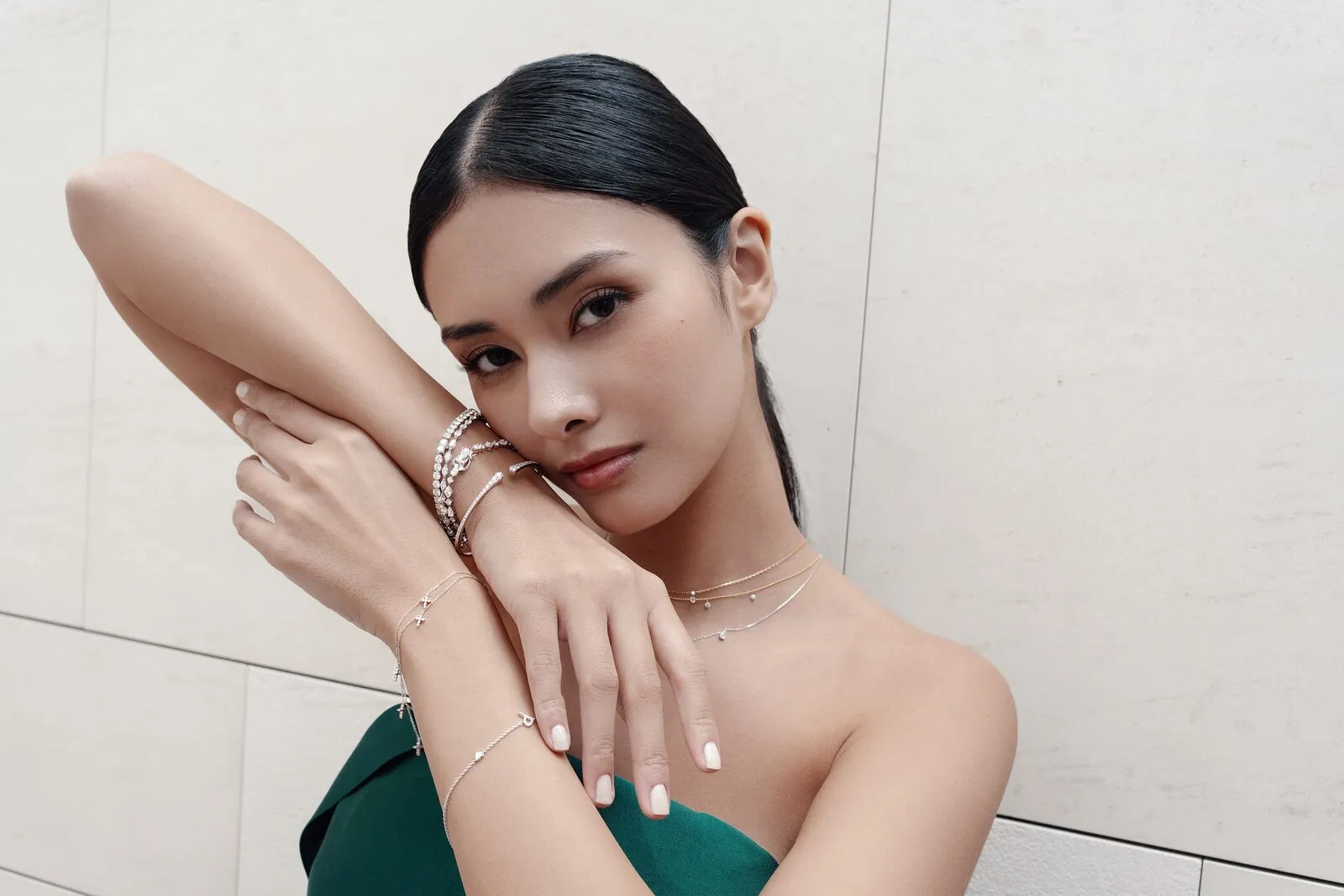 Diamond tennis bracelets, bangles and layered chains worn across the arm