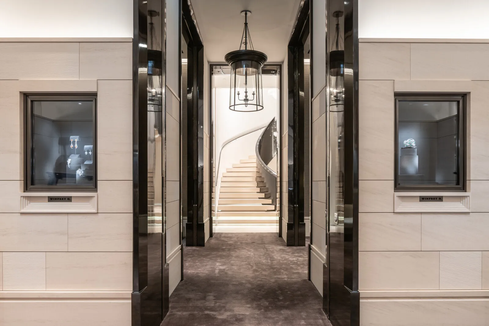 The view through mirrored doorways, vitrines either side, the staircase at the far end