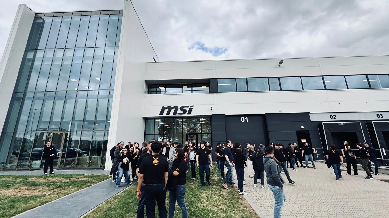 Het team verzamelt zich voor het gebouw in Helmond, met het MSI-logo boven de ingang