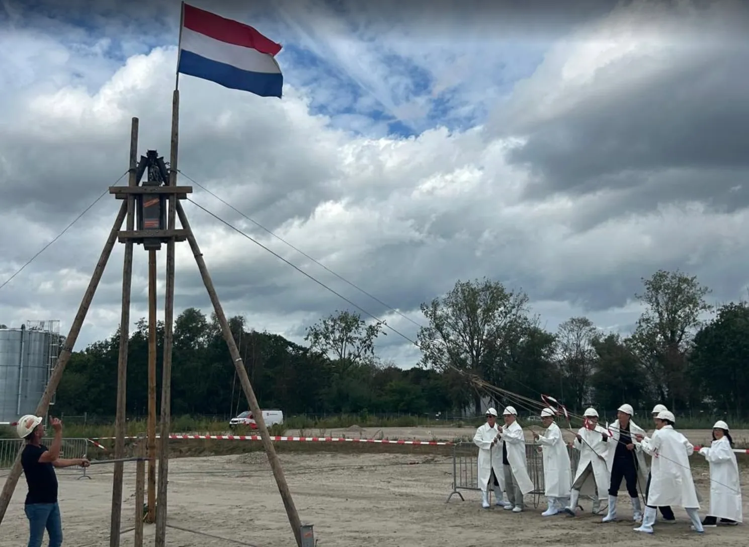 Het houten heiblok onder de Nederlandse vlag, met de ploeg in witte jassen ernaast