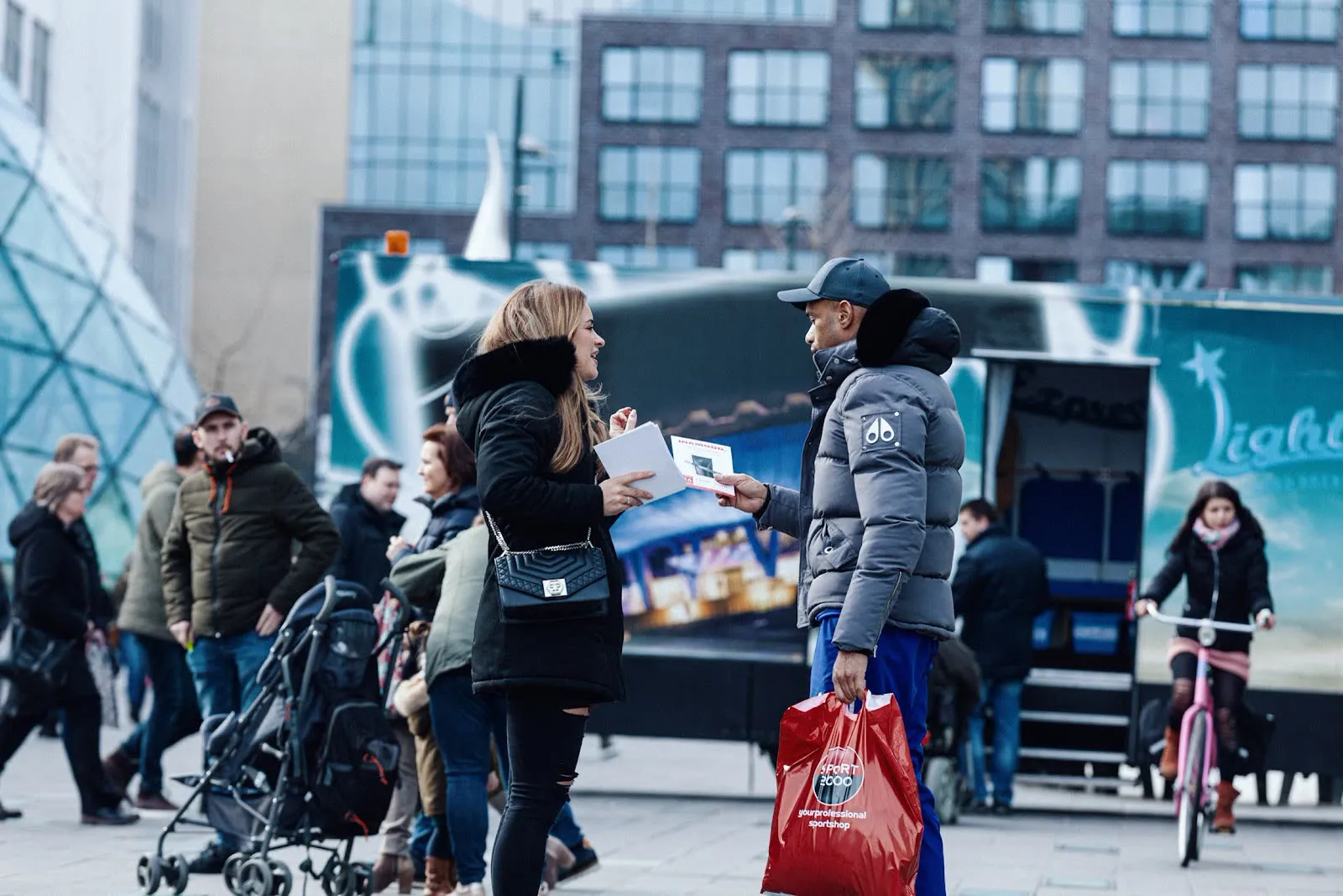 A promoter handing an INAMOOD flyer to a passer-by in the city centre
