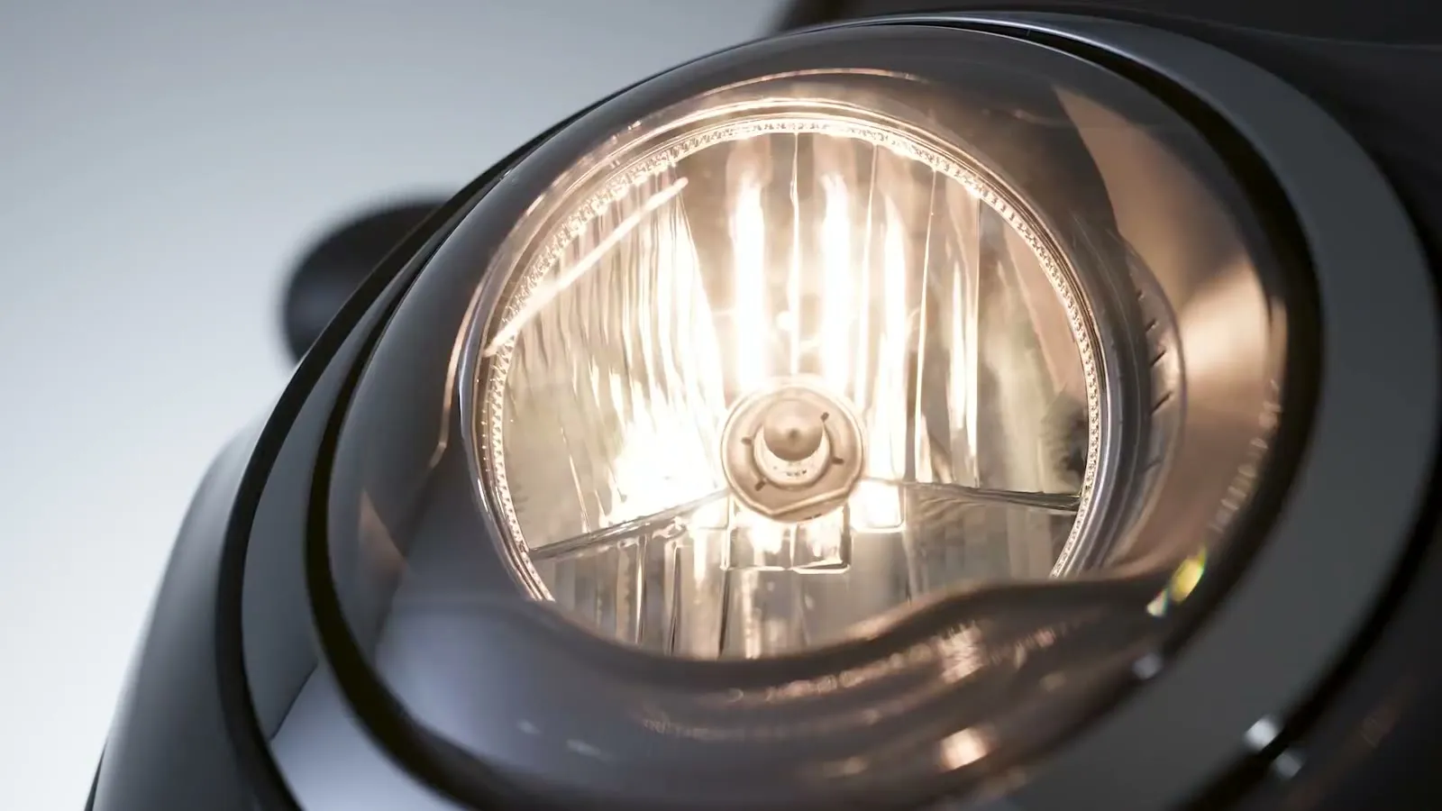 The headlight lit against the dark bodywork