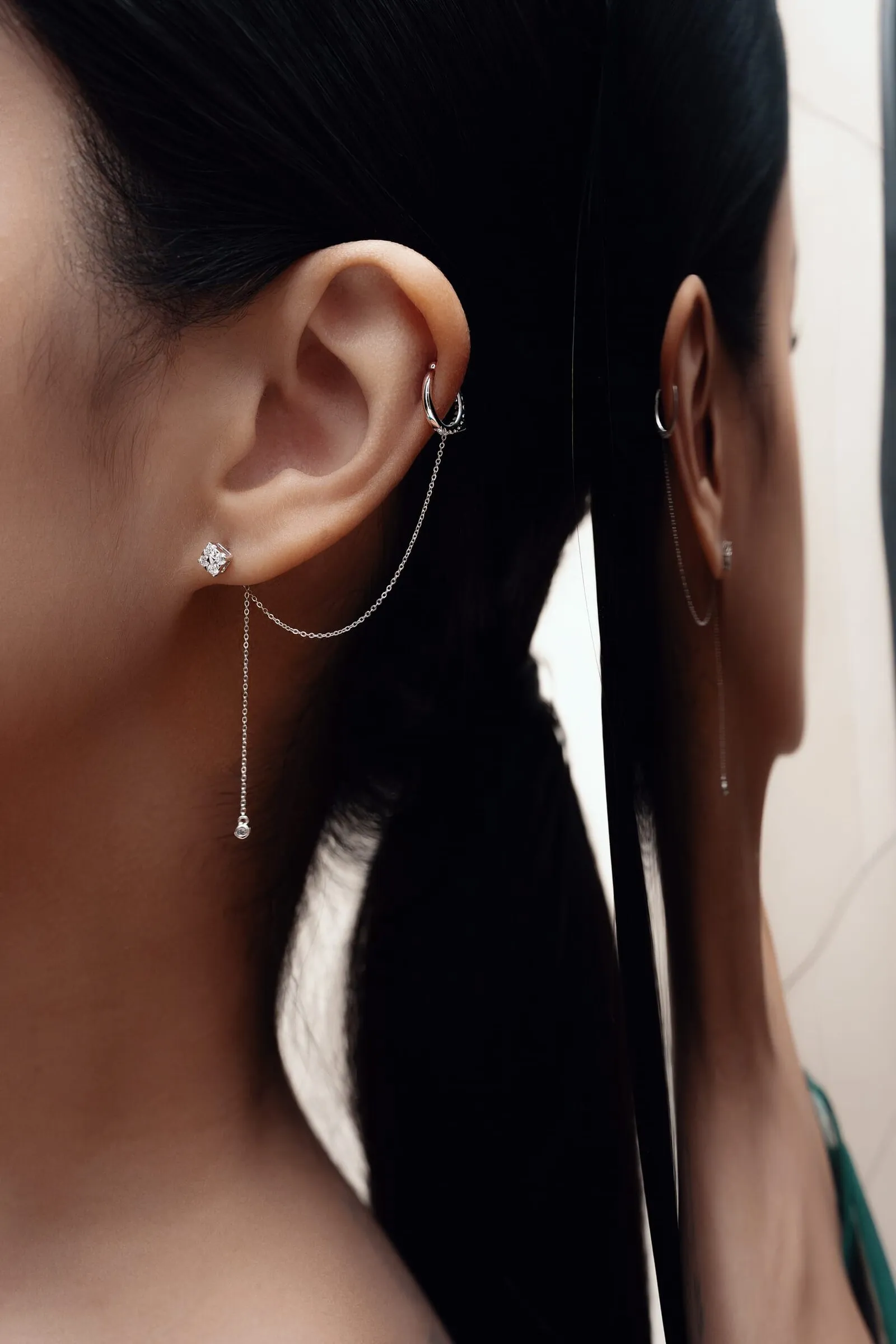Diamond ear chain running from the lobe to a helix hoop, doubled in a mirror