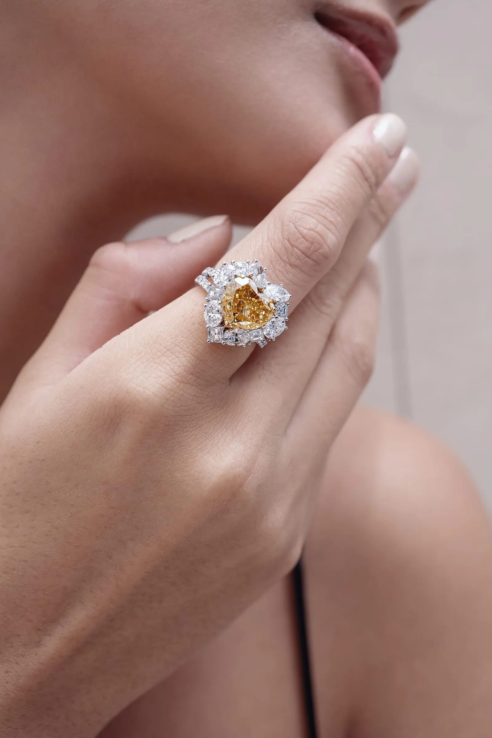 Heart-cut fancy yellow diamond ring in a cluster of white pear and emerald cuts