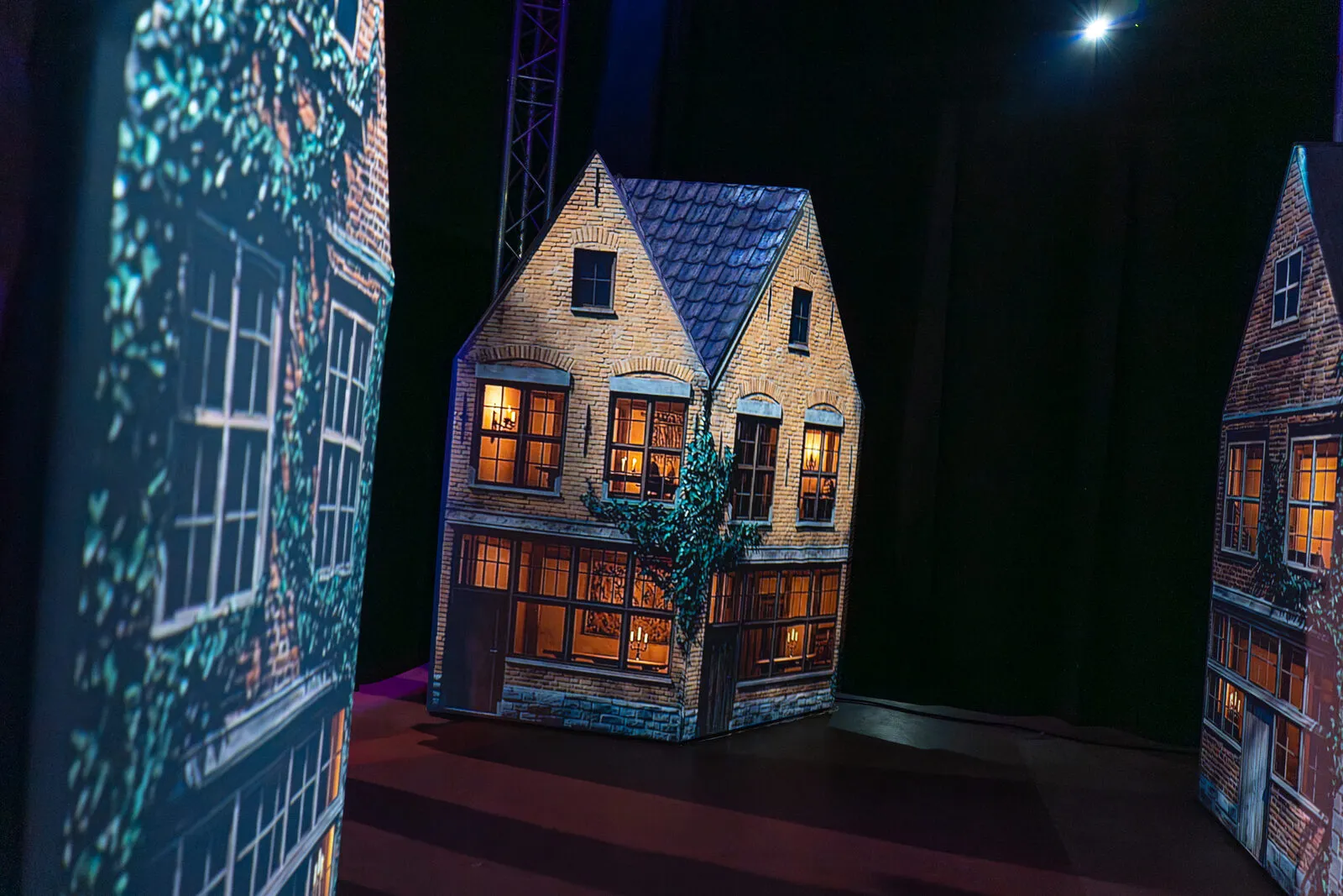 Projection mapped onto model canal houses, windows and brickwork lit from the beam
