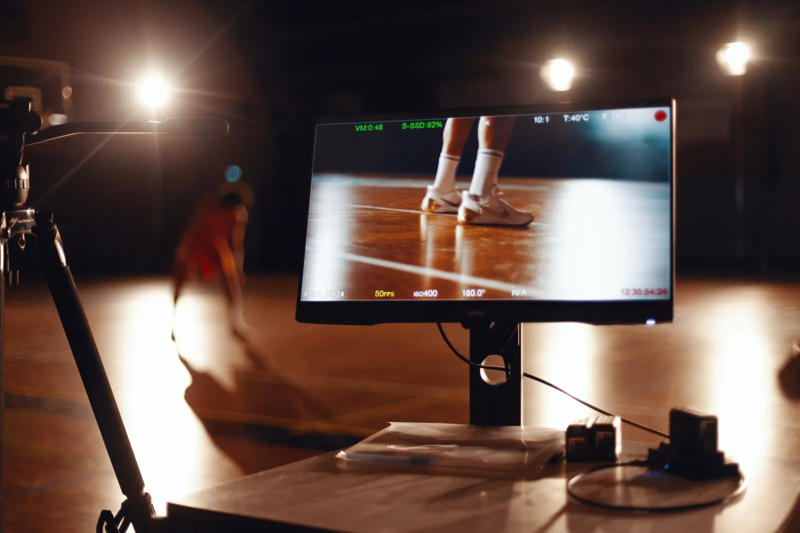 Een lage camera op de vloer, een speler dribbelt in de uitgelichte baan erachter