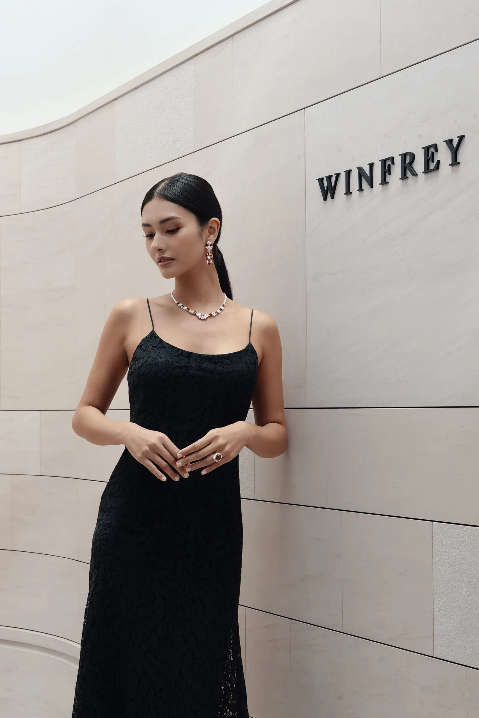 Full-length frame in black lace beside the curved stone facade and the Winfrey lettering