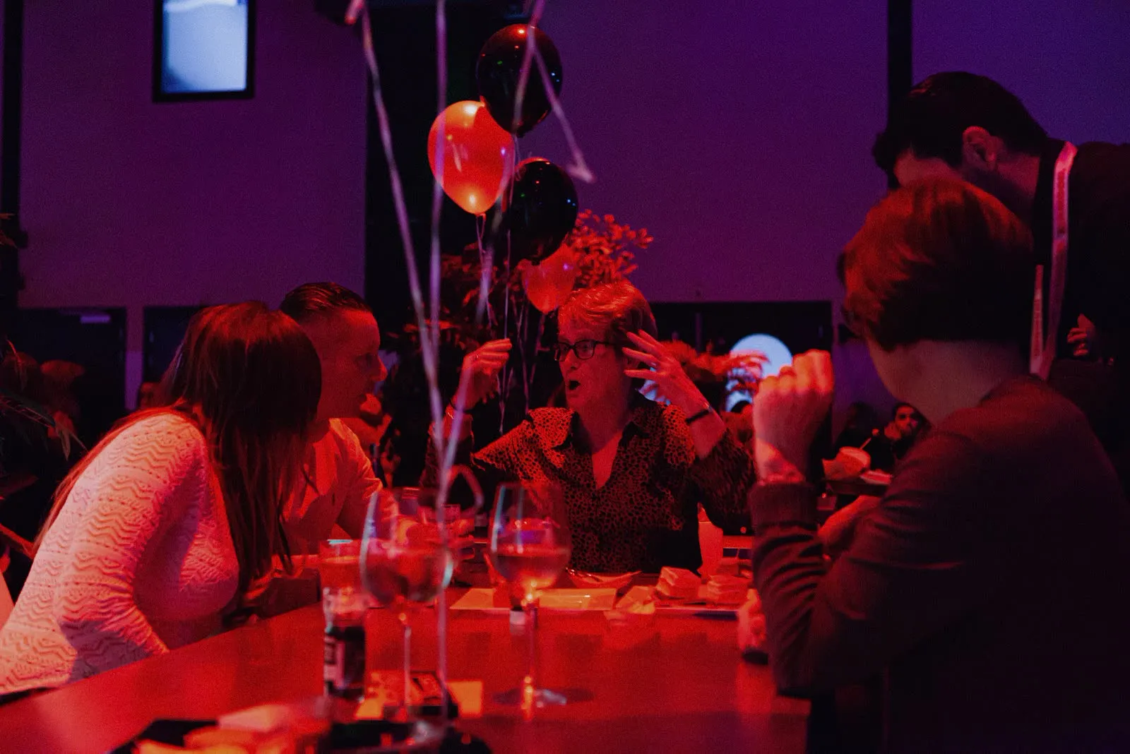 Guests at the tables under red light with INAMOOD balloons