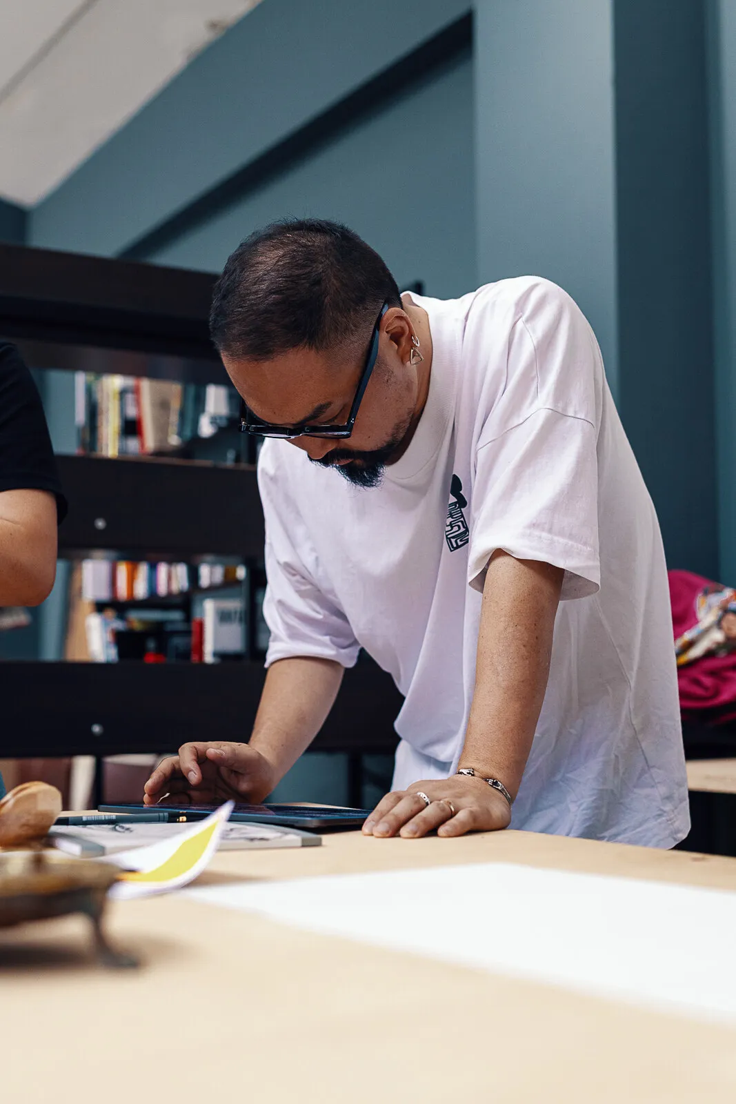 Takumi Ogata leaning over the table, working through a proof