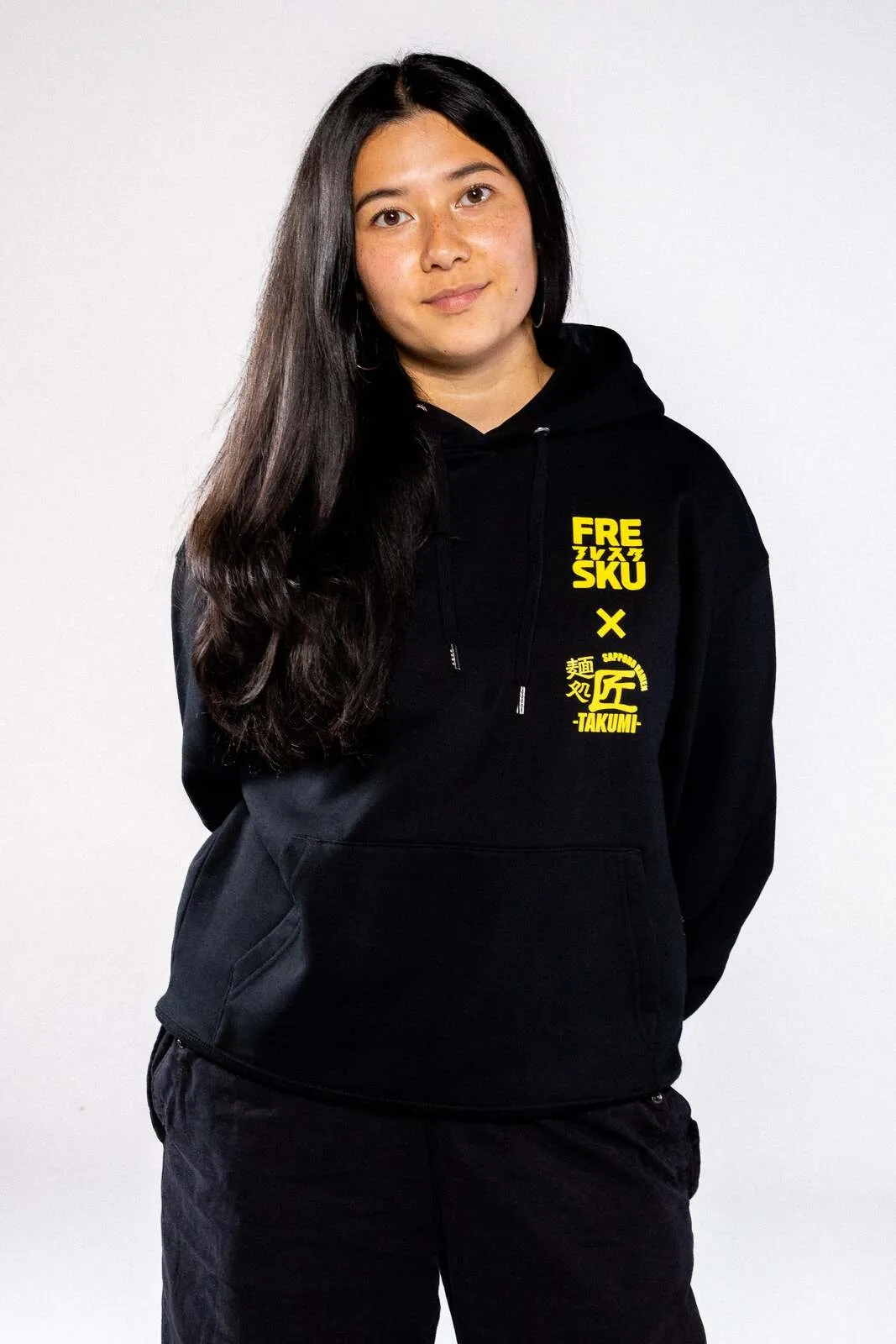 The black Fresku x Takumi hoodie, Ogata's faces artwork across the back
