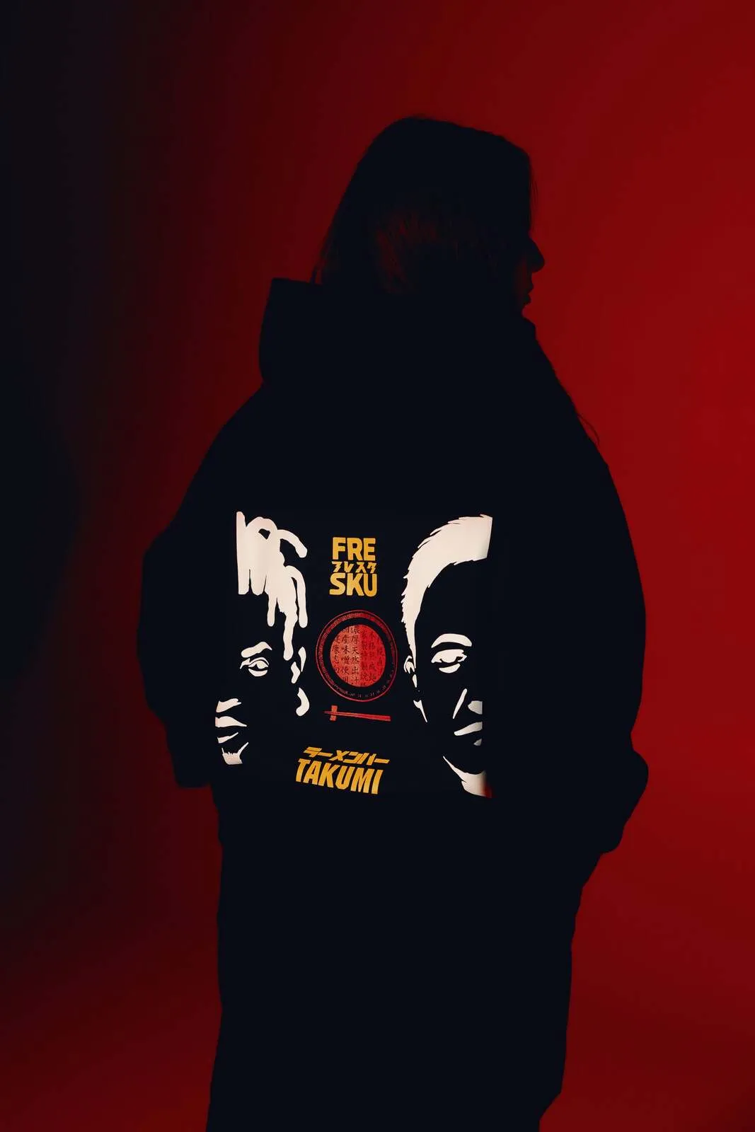 The black Fresku x Takumi hoodie, Ogata's faces artwork across the back
