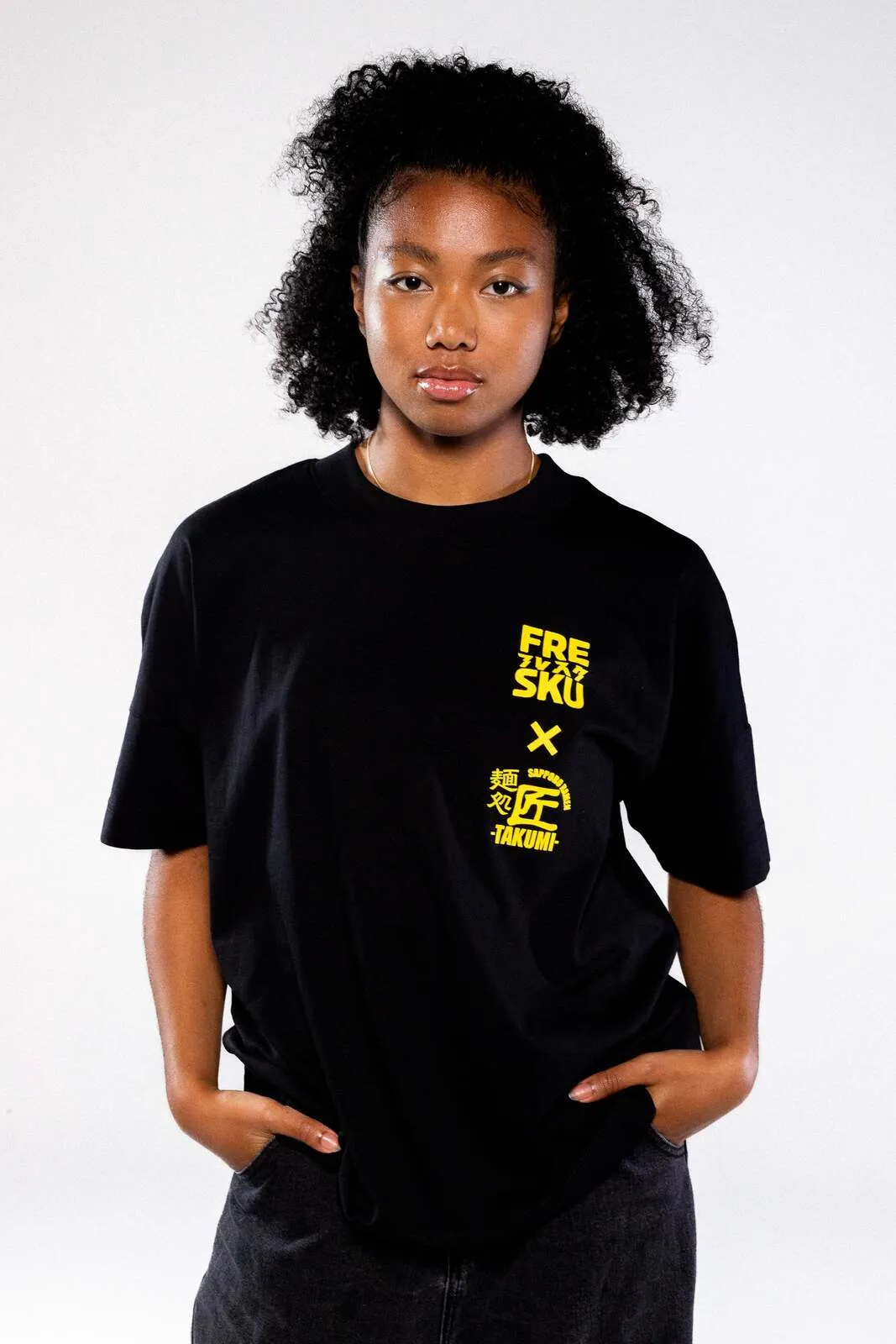 The black Fresku x Takumi t-shirt, the chest lockup picked out in yellow
