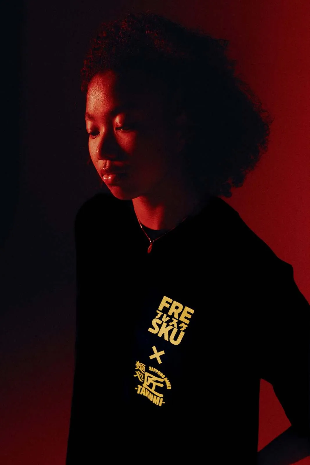 The black Fresku x Takumi t-shirt, the chest lockup picked out in yellow