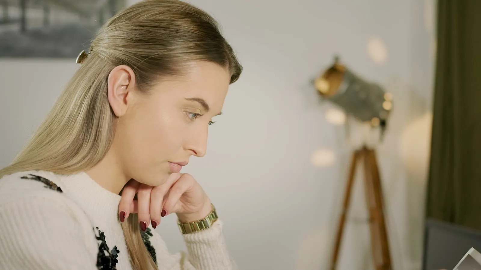 A colleague at the table, thinking, warm light behind her