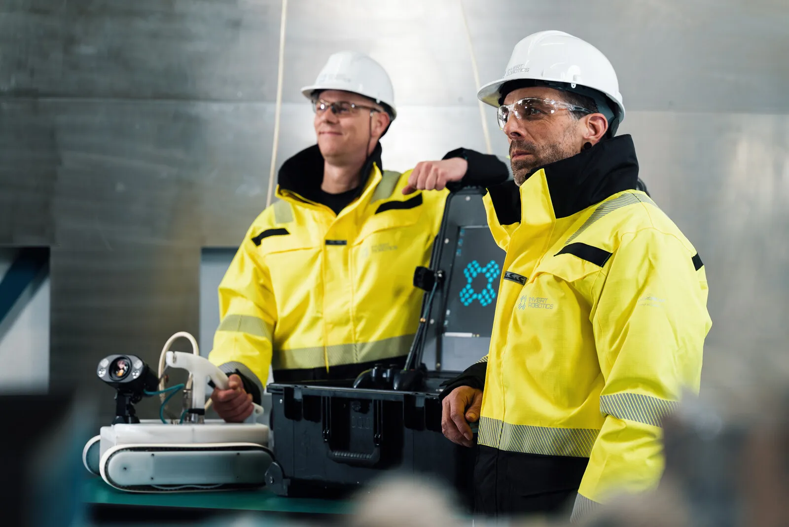 Two operators in hi-vis and hard hats at the control case