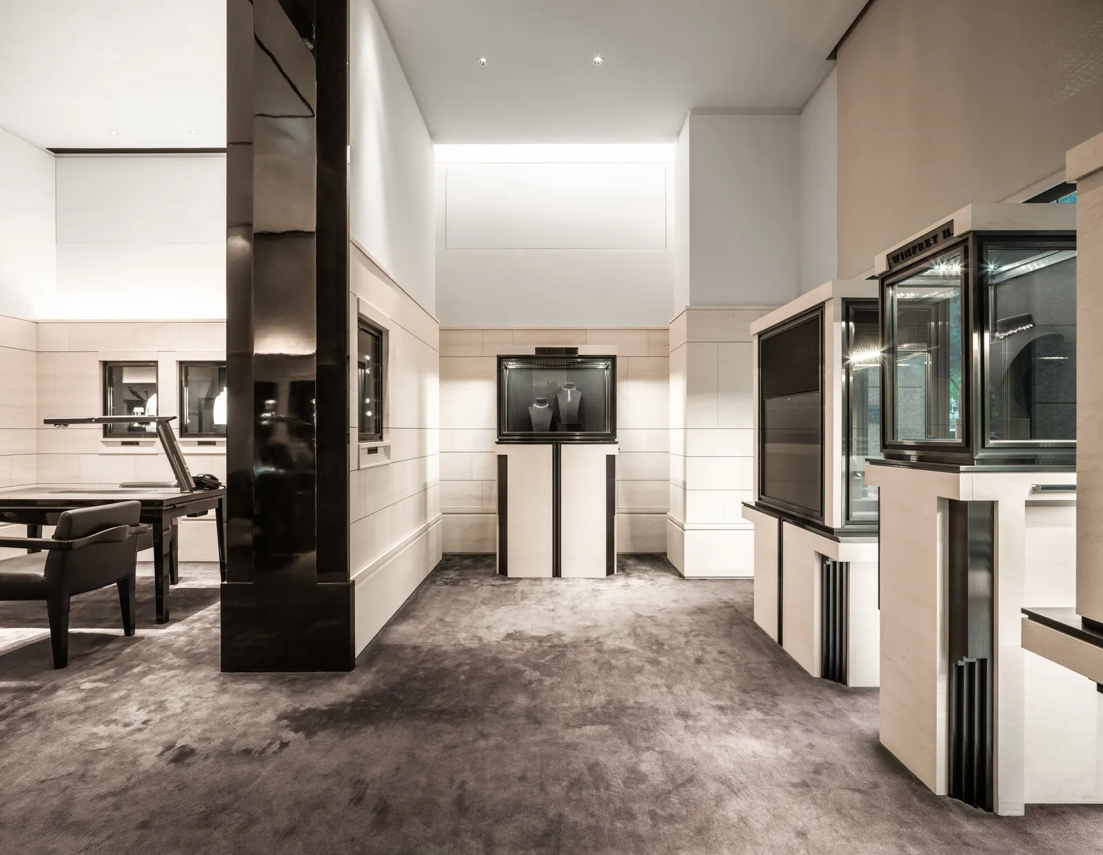 The retail floor, display cases and consultation tables under a double-height ceiling